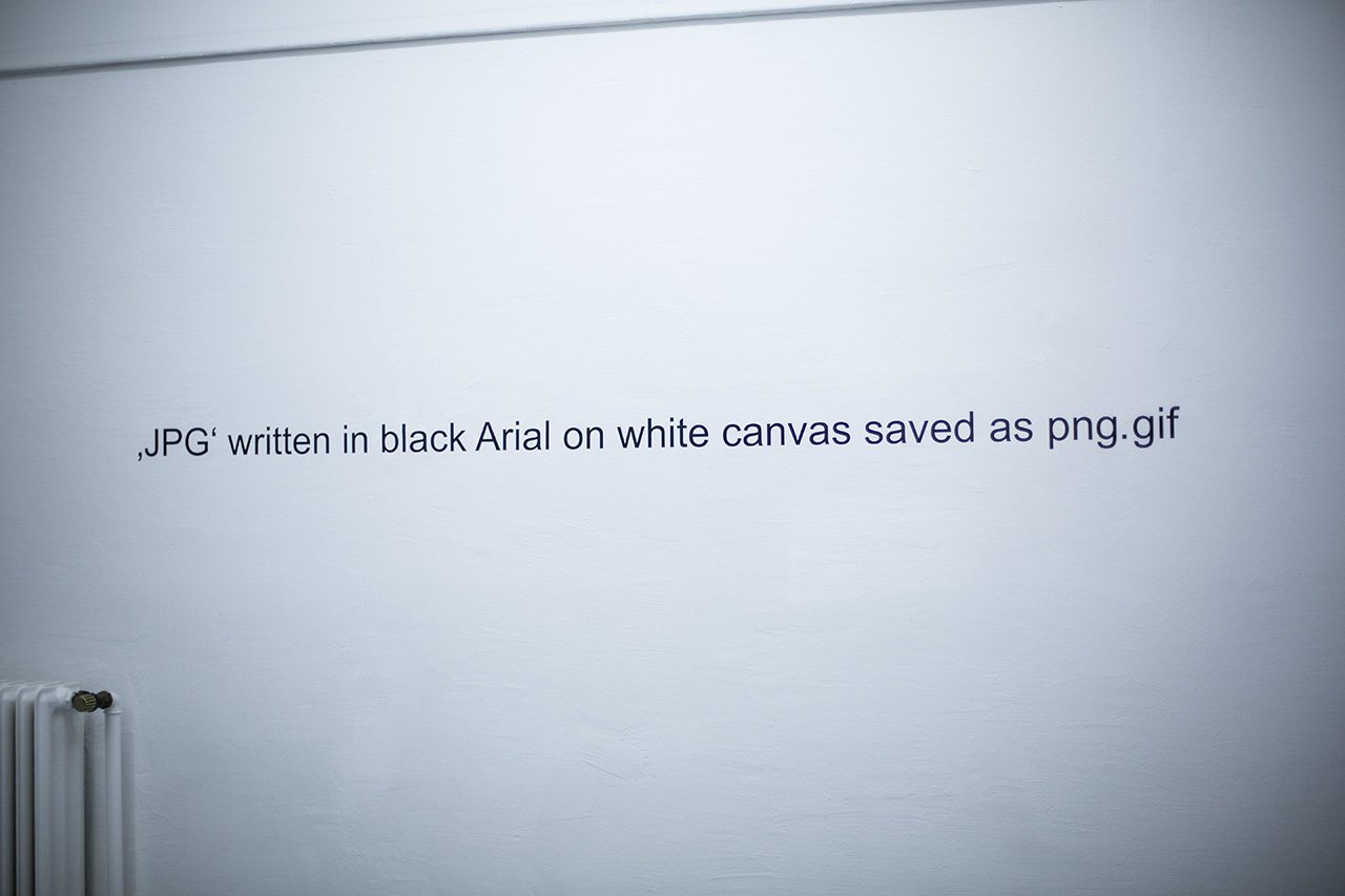 Wall text JPG written in black Arial on white canvas saved as png.gif in the white cube