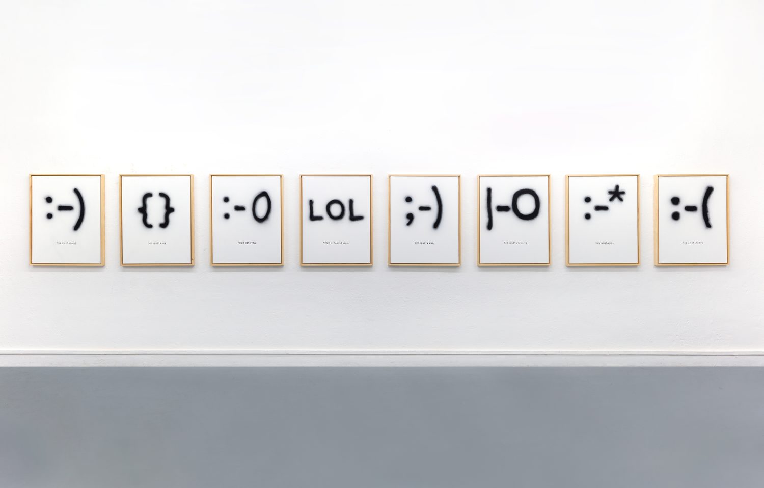 Inside Out — the full row of framed emoticons :-) {} :-O LOL ;-) |-O :-* :-( on the white wall
