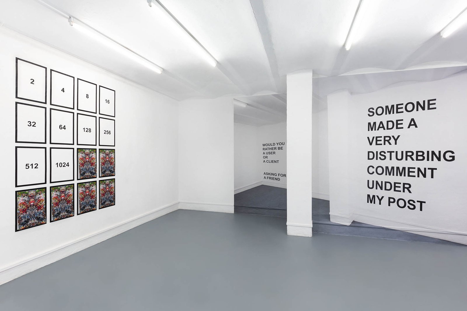 Installation view: the doubling grid of prints and the wall text SOMEONE MADE A VERY DISTURBING COMMENT UNDER MY POST