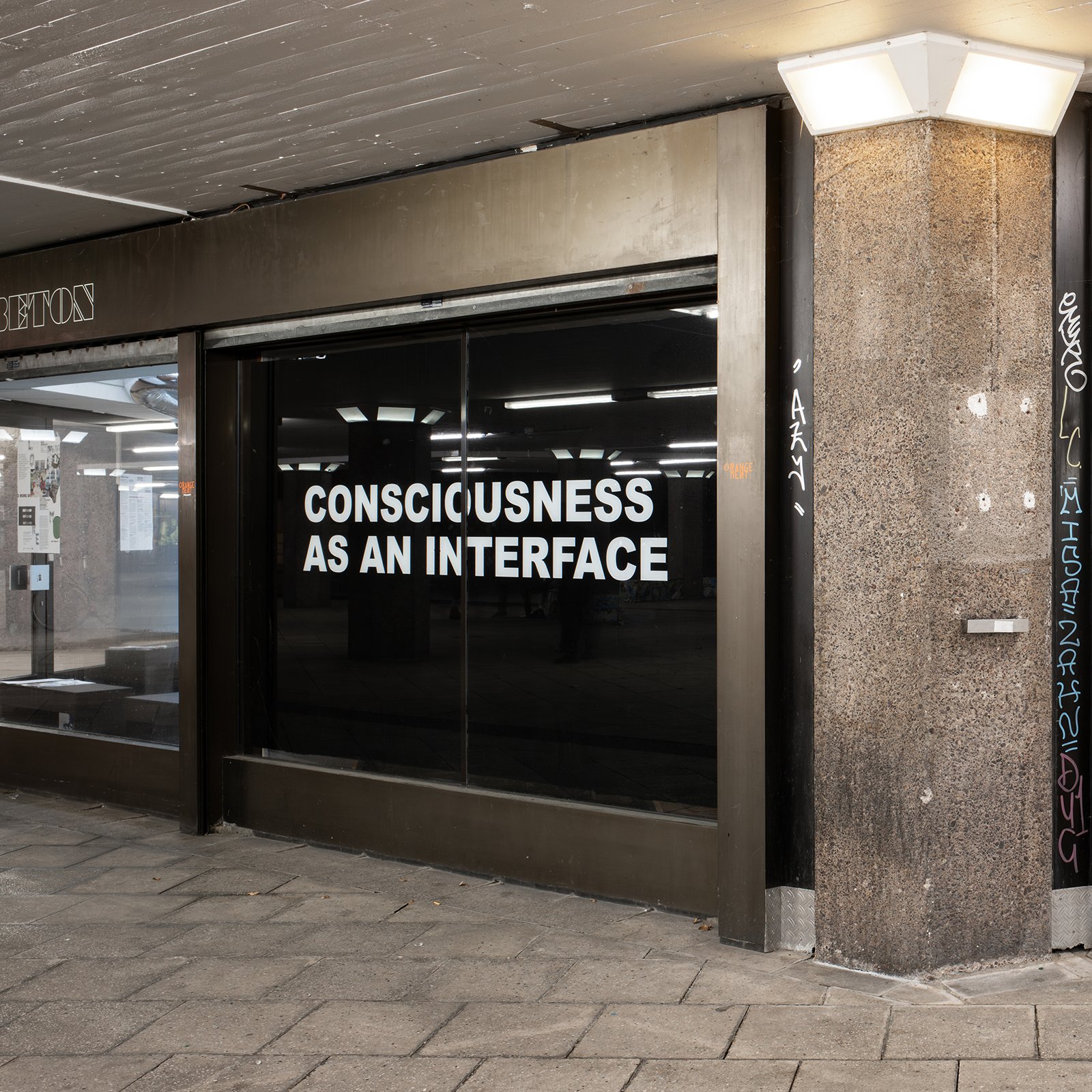 Shop window in the Ebertplatz passage reading CONSCIOUSNESS AS AN INTERFACE