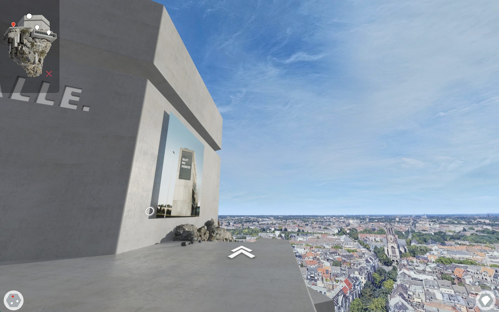 The work REALITY WAS OVERRATED set into the concrete wall, the city panorama beyond