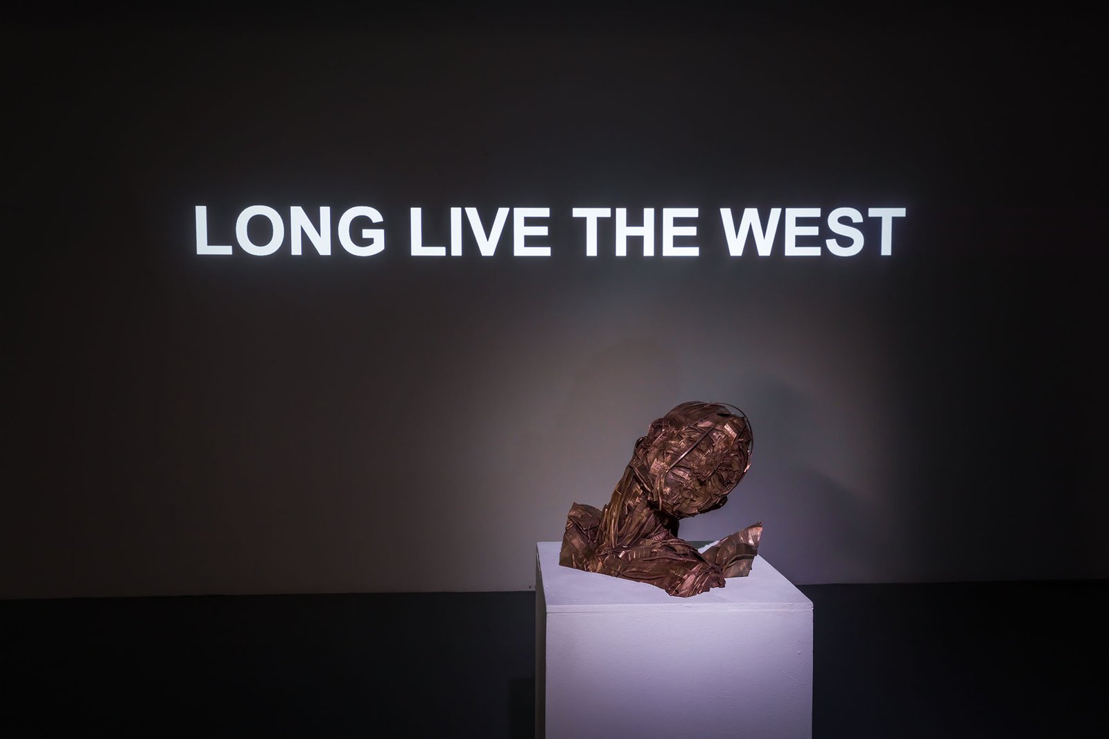 Dennis Rudolph's cast bronze bust on a plinth beneath the words LONG LIVE THE WEST